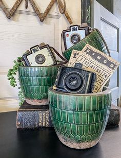 two green planters sitting on top of a table