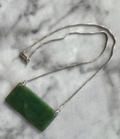 Hand-carved from jade harvested from under the waves off the Big Sur coast, this one-of-a-kind pendant comes on a 16-inch silver chain. Elegant Jade Necklace With Large Pendant, Rectangular Jade Gemstone Necklaces, Rectangular Jade Gemstone Necklace, Artisan Silver Jade Necklace, Hand-strung Round Jade Necklaces, Carved Silver Jade Necklaces, Carved Silver Jade Necklace, Carved Jade Necklace In Silver, Ancient Hand Carved Light Green Jade Large Pendant Necklace