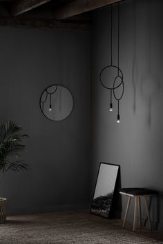 a black and white photo of a room with two mirrors, a potted plant and some lights