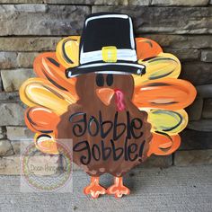 a turkey with a pilgrim hat on it's head is standing in front of a brick wall