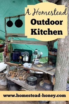 an outdoor cooking area with pots and pans on the table, next to a tree