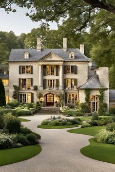 a large white house with lots of windows and bushes around the front entrance, surrounded by greenery