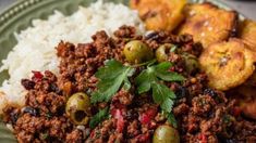 a close up of a plate of food with rice and olives on the side