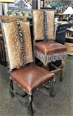 two brown leather chairs sitting next to each other on top of a carpeted floor