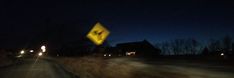 a blurry photo of a street sign in the middle of the road at night