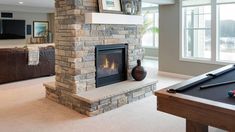 a living room with a pool table and fireplace