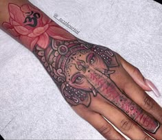 a woman's hand with an elephant tattoo on it and a flower in the middle