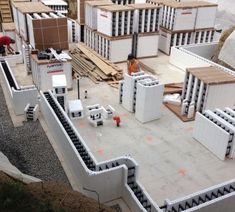 construction workers work on the roof of a building that is being built with cinder blocks