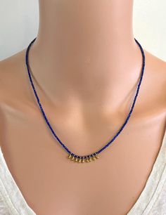 A dainty and versatile necklace of 2 mm faceted natural Lapis Lazuli round beads accented with gold-tone dangles. This necklace is 16.75" in length and has a 2" gold-filled extender chain so you can wear it short or long.  It looks great on its own or when worn in layers. It has gold-filled findings. NM Jewelry Design offers one-of-a-kind and limited edition jewelry. My creations are inspired by the cultures that traded along the ancient Silk Road. I am a Certified Gemologist and Accredited Jewelry Professional.   Please contact me for more information about the other necklaces shown in this listing. Gold Teardrop Beaded Necklaces With Dangling Beads, Gold Teardrop Beaded Necklace With Dangling Beads, Dainty Gold Necklaces With Dangling Beads, Dainty Gold Necklace With Dangling Beads, Bohemian Gold Charm Necklaces With Dangling Beads, Gold Dainty Rondelle Beaded Necklaces, Bohemian Gold Charm Necklace With Dangling Beads, Drop Necklace With Dangling Round Beads For Gift, Gold Rondelle Beaded Necklaces