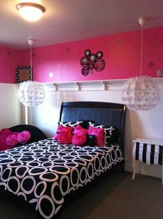 a black and white bed with pink pillows in a girls's bedroom decorated for the holidays