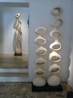 there are several sculptures on display in the room with white walls and stone flooring