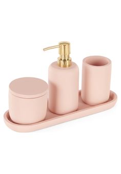 a pink soap dispenser and two cups on a tray