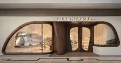 an architectural rendering of a storefront with curved windows and arched wooden doors that lead to the second floor