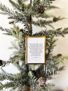 a christmas ornament hanging from the top of a pine tree with a poem on it