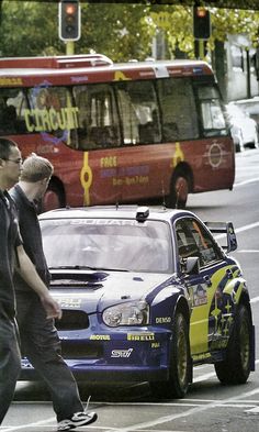 two men crossing the street in front of a car