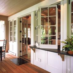 a dining room and kitchen area with wooden floors