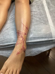 a woman's foot with a tattoo on it sitting on top of a bed