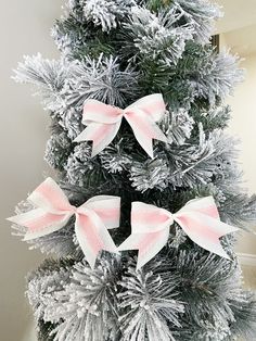 a christmas tree decorated with pink and white bows