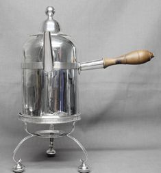 a silver coffee pot with a wooden handle