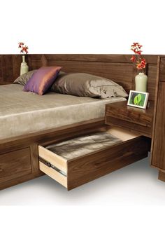 a bed with two drawers underneath it and a pillow on the bottom one drawer is open