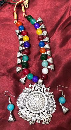 This style of Choker and Earrings set is a traditional and iconic style of jewelry that originated from India and is popular throughout the Indian subcontinent. This set is known for it's distinctive design. This type of jewelry is a significant part of Indian culture and is worn by women on various occasions, including weddings, festivals, and other celebrations. The choker necklace has a detailed design in the pendant and colorful beads in necklace make this a beatiful set to treasure.  Versatility: This set commonly worn with traditional Indian attire such as sarees and lehengas, they can also be paired with contemporary outfits to add a touch of elegance and ethnicity to one's look. Size: Adjustable necklace Color & Design:  Multi color Note: earrings are for pierced ears only, the nec Multicolor Jewelry With Matching Round Earrings, Multicolor Jewelry With Matching Earrings, Vintage Multicolor Jewelry With Matching Earrings, Multicolor Metal Costume Jewelry, Festival Necklaces With Matching Earrings And Round Shape, Festival Metal Necklace With Matching Earrings, Festival Necklace Set With Matching Earrings And Round Shape, Festival Necklace Set With Matching Earrings, Festival Metal Necklaces With Matching Earrings