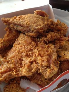 some fried food in a white container on a table