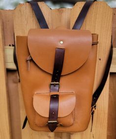 "A beautiful, two-tone brown leather backpack for outside adventures or daily wear. This was the first backpack I ever created and it was a very fun challenge.  I hope you'll enjoy using it as much as I enjoyed making it. Details: - 100% genuine full-grain leather  - The leather does have some unique characteristics and some blemishes - Two pockets, one on the outside and one on the inside - Medium brown chrome-tan leather and dark brown, veg-tan leather straps - Antique brass buckles, double-cap rivets, and square rings - Hand stitched with dark brown 1.0mm Ritza 25 Tiger thread - Very stiff backpack. It will stand on its own and not collapse down. - Design is from Karlova Design and called the \"Sloop\" backpack Measurements: Height - 12\" Width - 8.25\" Depth - 4\" Outside Pocket Height Outdoor Brown Backpack With Leather Backing, Brown Leather Backpack With Leather Lining For Outdoor, Brown Waxed Leather Backpack For Outdoor, Outdoor Brown Backpack With Leather Lining, Brown Outdoor Backpack With Leather Handles, Brown Backpack With Leather Handles For Outdoor, Brown Leather-backed Adventure Backpack, Brown Leather-lined Backpack, Adventure Brown Leather Backpack