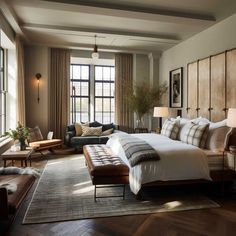 a bedroom with a large bed and two couches in front of the big windows