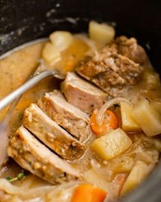 a bowl filled with meat, potatoes and carrots