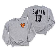 Step up your style game with this personalized crewneck sweatshirt! Our custom crewneck sweatshirt comes with a cute pocket size  basketball heart on the front. But that's not all - the customization doesn't stop there. We've also added a custom name and or number on the back, giving this sweatshirt a personalized touch. Stay cozy, make a statement, and showcase your individuality with our one-of-a-kind crewneck sweatshirt. If you like your sweatshirts loose or oversized, you might want to order a size up and if you'd like a more fitted look then order a size down. WE RECOMMEND MEASURING YOUR FAVORITE FITTING SWEATSHIRT AND COMPARING TO THE MEASUREMENTS ON THE SIZE Chart.  These are Gildan brand sweatshirts.  **Ships with in 3-7 business days** Every tee is handmade to order with love. Ple Customizable Crew Neck Sweatshirt For Game Day, Customizable Crew Neck Sweatshirt For Sports Events, Game Day Crew Neck Sweater, Customizable Crew Neck Tops For Sports Events, Custom Print Long Sleeve Sweatshirt For Sports, Relaxed Fit Crew Sweatshirt With Team Name, Game Day Sweatshirt With Custom Print And Crew Neck, Game Day Sweatshirt With Custom Print Crew Neck, Team Spirit Long Sleeve Sweatshirt With Custom Print