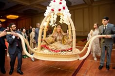 a bride and groom sitting on a bed in front of a group of other people