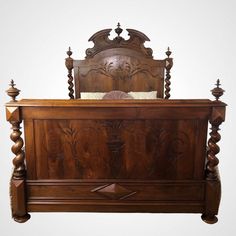 a wooden bed frame with intricate carvings on the headboard