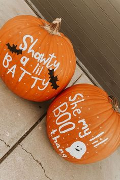 two pumpkins that have been painted with words on them