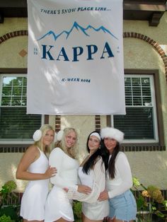 three women in white dresses standing next to a sign that says kappa on it