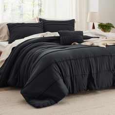 a bed with black comforter and pillows in a room