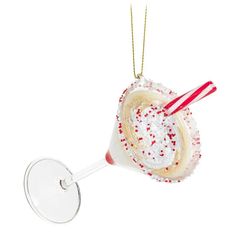 a glass ornament with a candy cane in it's mouth and sprinkles on the rim