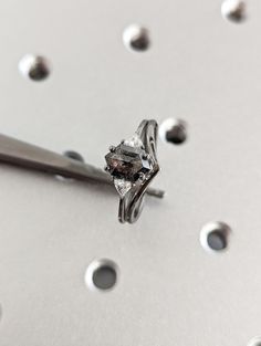 a diamond ring sitting on top of a metal surface