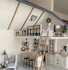 a loft bed with stairs leading up to the top floor and below it is a kitchen