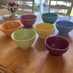 seven bowls are lined up on a table