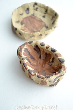 two ceramic bowls sitting on top of a white table