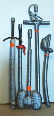 several metal pipes and tools are lined up on the floor in front of a wall