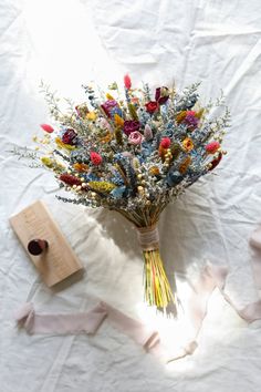 a bouquet of flowers sitting on top of a white sheet