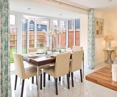 the dining room table is set with beige chairs