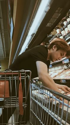 a woman leaning over a shopping cart in a store