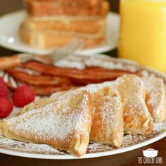 two plates with pastries, raspberries and bacon on them next to a glass of orange juice