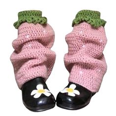 a pair of black and pink crocheted shoes with flowers on the soles