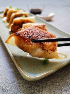 a white plate topped with food and chopsticks