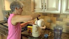 an older woman is using a blender on the counter