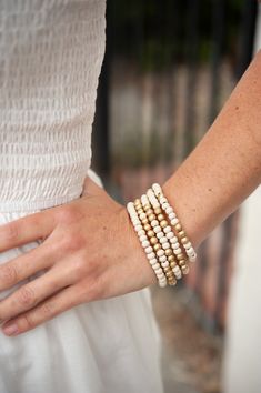 Introducing the Eleni Natural Wood Beaded Bracelet Stack, a captivating set that brings together the earthy allure of natural wood with the subtle glamour of gold accents. This boho-inspired bracelet stack features a combination of wood and gold Pisa beads, creating a harmonious and stylish blend. The stack includes multiple bracelets that can be layered together for a trendy and personalized look. The Eleni Natural Wood Beaded Bracelet Stack is perfect for those who appreciate the bohemian aest Natural Wooden Beads Bracelet, Everyday Beige Jewelry With Wooden Beads, Adjustable Gold Bracelets With Wooden Beads, Gold Bracelets With Wooden Round Beads, Bohemian Gold Beaded Bracelet With Wooden Beads, Gold Stacked Bohemian Bracelets, Beige Bracelets With Wooden Round Beads, Everyday Gold Stretch Bracelet With Wooden Beads, Bohemian Gold Stretch Bracelet With Wooden Beads