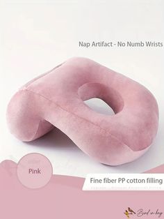 the pink pillow is shaped like a large donut, and sits on top of a white surface